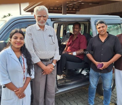 A close-up photograph of 73-year-old Mohanan looking weary but relieved, sitting at the Kuttippuram railway station while local social workers and Selva Care coordinators stand supportively beside him during his rescue.